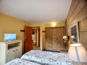 um quarto com uma cama, uma secretária e uma televisão em Appartement Les Menuires, 2 pièces, 5 personnes - FR-1-178-294 em Les Menuires