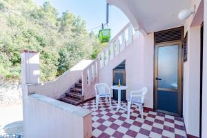 a house with a checkered floor and a table and chairs at Apartmani Antula in Prigradica