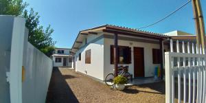 une maison blanche avec un vélo garé devant elle dans l'établissement Aluguéis Cleusa, à Torres