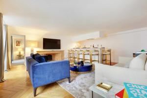 Il comprend un salon avec un canapé bleu et une cuisine. dans l'établissement Amazing apartment 2BR4P avenue Montaigne Triangle d'Or, à Paris