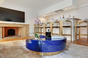 uma sala de estar com uma mesa azul e uma lareira em Amazing apartment 2BR4P avenue Montaigne Triangle d'Or em Paris