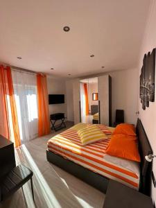 1 dormitorio con 1 cama grande con manta naranja en Simply House Civitavecchia en Civitavecchia