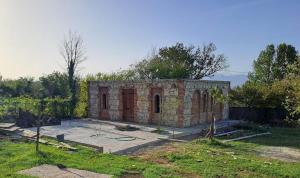 een bakstenen gebouw in een tuin met een tuin bij Kutaisi Center Guesthouse in Koetaisi