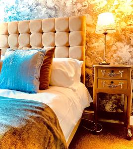 a bedroom with a king sized bed with a blue pillow at The Capon Tree Town House in Jedburgh