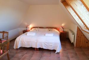 ウィトデュンにあるFerienhaus am Kniepのベッドルーム1室(白いベッド1台、タオル2枚付)