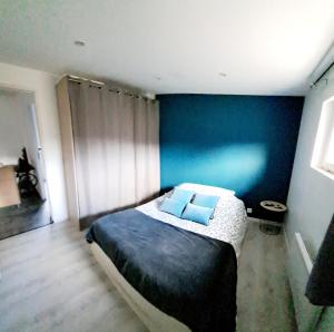 - une chambre dotée d'un lit avec un mur bleu dans l'établissement Gîte "les jujubiers", à Plan-dʼOrgon