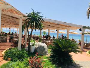 - un restaurant sur la plage avec des tables dans l'établissement Hotel Grotticelle, à Capo Vaticano