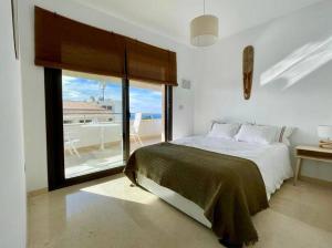een slaapkamer met een bed en een groot raam bij Beautiful flat with a wonderful view close to the beach in Marbella