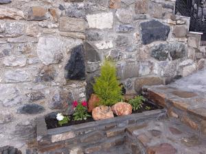 a stone wall with flowers and plants in a stone planter at Villa Maria 