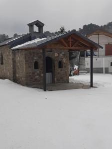 un bâtiment en pierre avec un toit dans la neige dans l'établissement Villa Maria, 