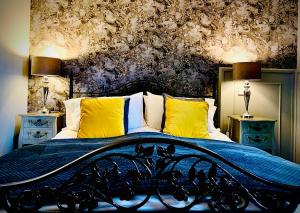 a bedroom with a large bed with yellow pillows at The Capon Tree Town House in Jedburgh