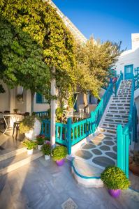 een trap met een blauw hek en bomen en planten bij Pension Marias in Mykonos-stad