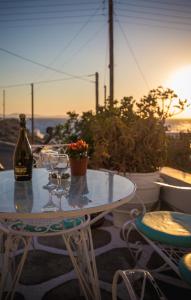 een tafel met wijnglazen en een fles wijn bij Pension Marias in Mykonos-stad