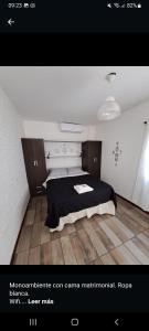 1 dormitorio con 1 cama con manta negra en Monoambientes Arizu en Godoy Cruz