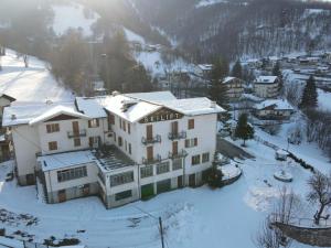 a large white building in the snow with a mountain at Hotel Skilift - Dada Hotels in Frabosa Soprana