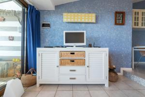 a white cabinet with a tv on top of it at Domus Luna Apartment with sea view Villasimius in Villasimius