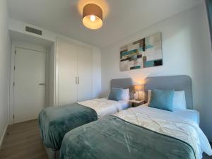 - une chambre avec deux lits et une lumière dans l'établissement Zen Apartment Estepona, à Estepona