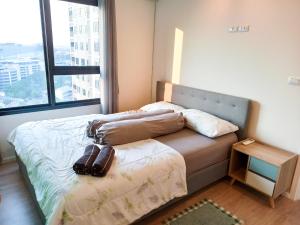 a bed in a room with a large window at Nice place near the city and shopping center in Chiang Mai