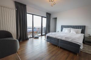 a bedroom with a large bed and a large window at Pensiunea CityView in Câmpulung Moldovenesc