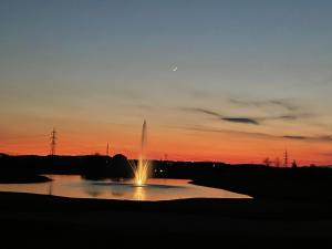 a fountain in a pond with a sunset in the background at Appartamento Stella in Pozzolengo