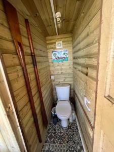 a bathroom with a toilet in a wooden cabin at Hardwick View Lodge in Holmewood
