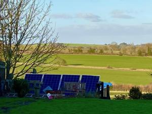 a house with a blue solar panel in a field at Hardwick View Lodge in Holmewood