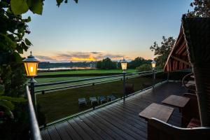 a deck with lights and tables and a view of a field at Hotel am Gothensee in Heringsdorf