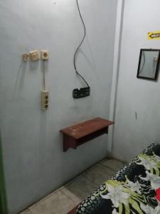 una camera con un letto e un telefono appeso a una parete di Hotel Griya Syar'i a Pekalongan
