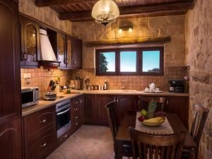 a kitchen with a table with chairs and a window at Villa Malaxa Private Luxury with Amazing View in Maláxa