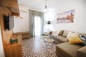 sala de estar con sofá y TV en RentalSevilla Cool flat in Triana with parking., en Sevilla