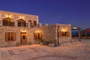 a large stone building with lights on it at Villa Malaxa Private Luxury with Amazing View in Maláxa