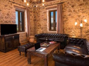 a living room with leather furniture and a television at Villa Malaxa Private Luxury with Amazing View in Maláxa