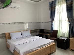 1 dormitorio con 1 cama, 1 silla y 1 ventana en Hải Phong hotel, en Dien Khanh