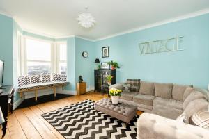 a living room with a couch and a table at 5-Bed House with distant sea views in Plymouth in Plymouth