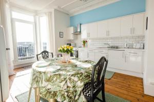 una cucina con tavolo e vaso di fiori di 5-Bed House with distant sea views in Plymouth a Plymouth