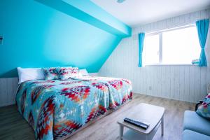 una camera blu con un letto e un tavolo di Yadoya YADOKARI a Pippu