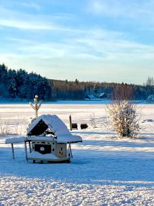 un campo cubierto de nieve con una mesa en la nieve en Salonsaaren Lomakylä en Asikkala