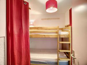 Zimmer mit 2 Etagenbetten und einem roten Vorhang in der Unterkunft Appartement Les Menuires, 2 pièces, 5 personnes - FR-1-178-88 in Les Menuires