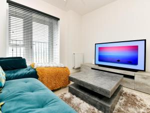 ein Wohnzimmer mit einem großen Flachbild-TV in der Unterkunft Pass the Keys Sleek 1 Bed Apartment w Parking in Cardiff