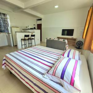1 dormitorio con 1 cama grande y cocina en Apt melhor localização da Barra, en Salvador