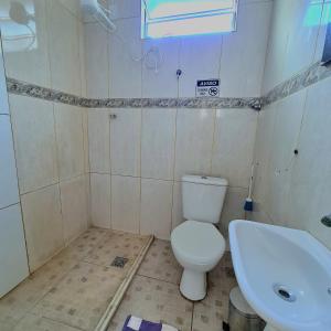 y baño con aseo y lavamanos. en Apt melhor localização da Barra, en Salvador