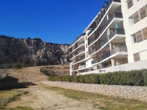 een wit appartementencomplex naast een berg bij T2 tout neuf avec Parking à 10km d'Aix et Marseille in Septèmes-les-Vallons