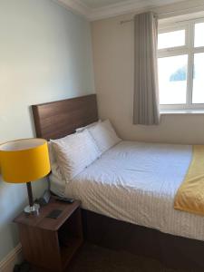 レッドカーにあるArmada Apartmentのベッドルーム1室(ベッド1台、ランプ、窓付)