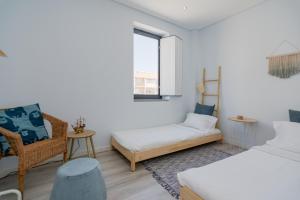 a bedroom with a bed and a couch and a chair at Casa Atelier in Setúbal