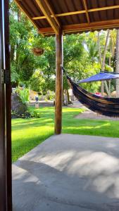 a hammock hanging from a pavilion in a garden at Casa Recanto das Mangueiras Japaratinga - Alagoas in Japaratinga