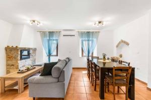 un soggiorno e una sala da pranzo con divano e tavolo di Villa Sweet Retreat a Baderna