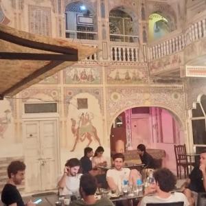 a group of people sitting at a table in a restaurant at HOTEL SHEKHAWATI HAVELI in Mandāwa