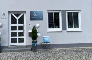 ein Haus mit einer Tür und einem Weihnachtsbaum davor in der Unterkunft Ferienwohnung Eden in Mellrichstadt