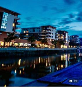 a city skyline with buildings and a river at night at Appartement haut standing F2 Rivetoile Strasbourg centre parking gratuit terrasse in Strasbourg