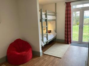 a bedroom with a bunk bed and a red chair at The Lodge in Llanbrynmair